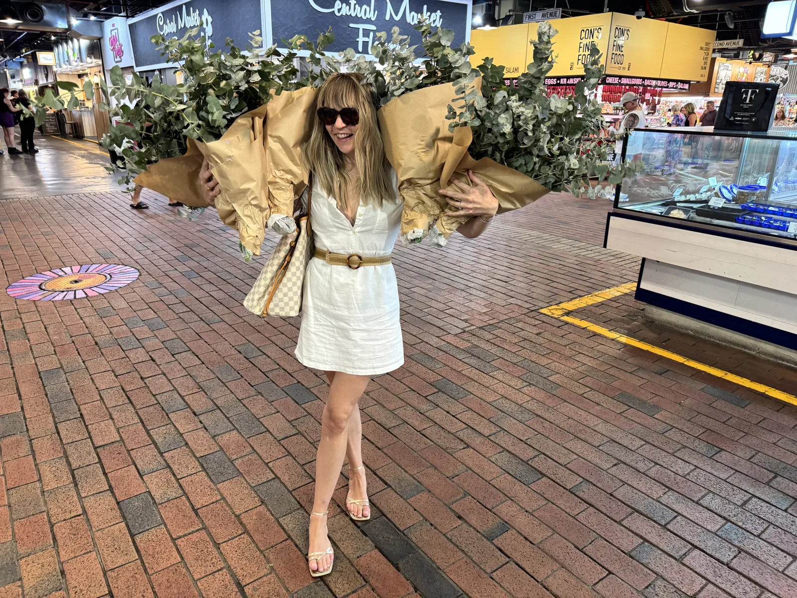 Meg at the market carrying two huge bunches of eucalyptus